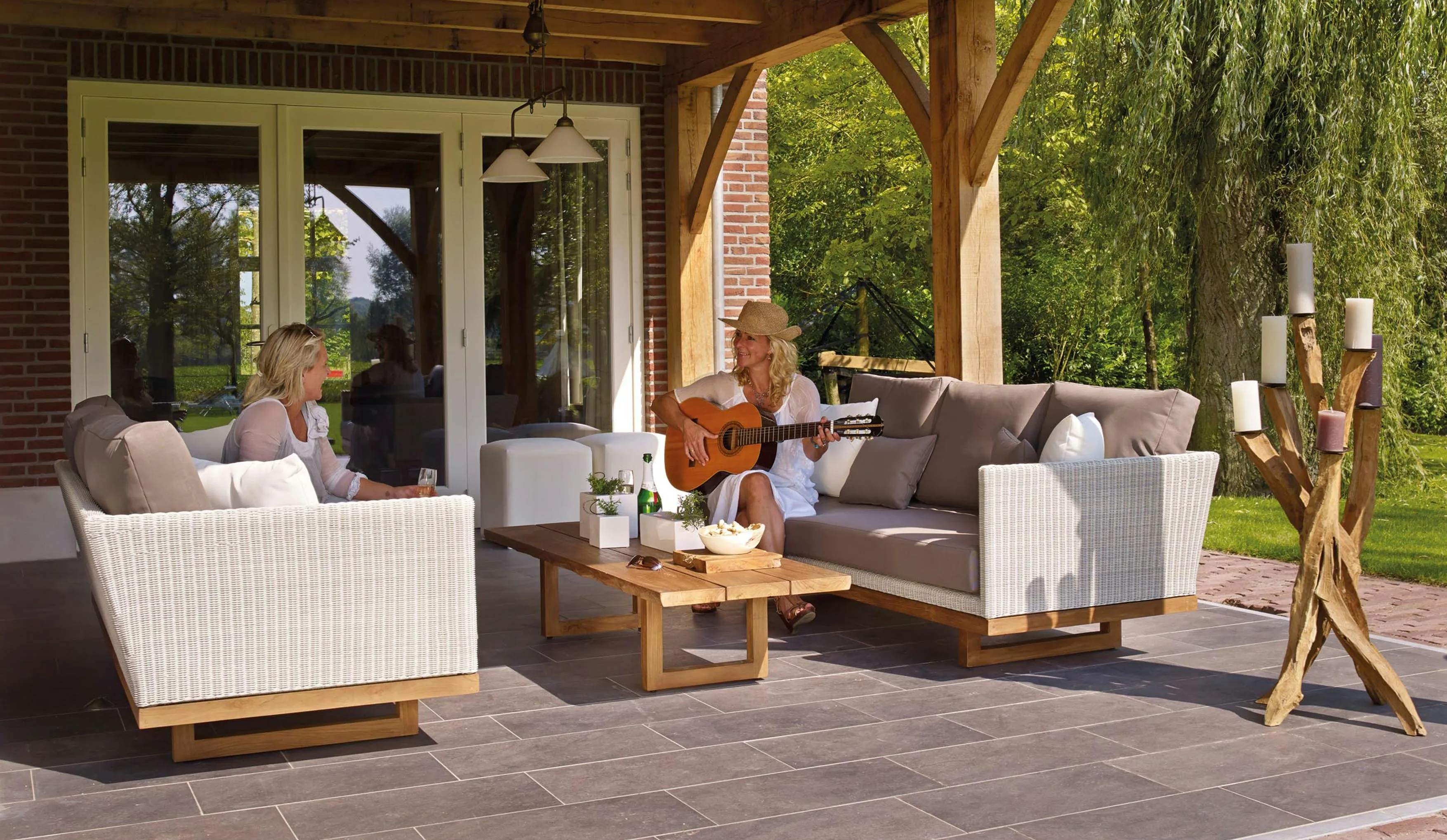 photo d'une terrasse haut de gamme avec deux personnes profitant du soleil assise sur la terrasse.